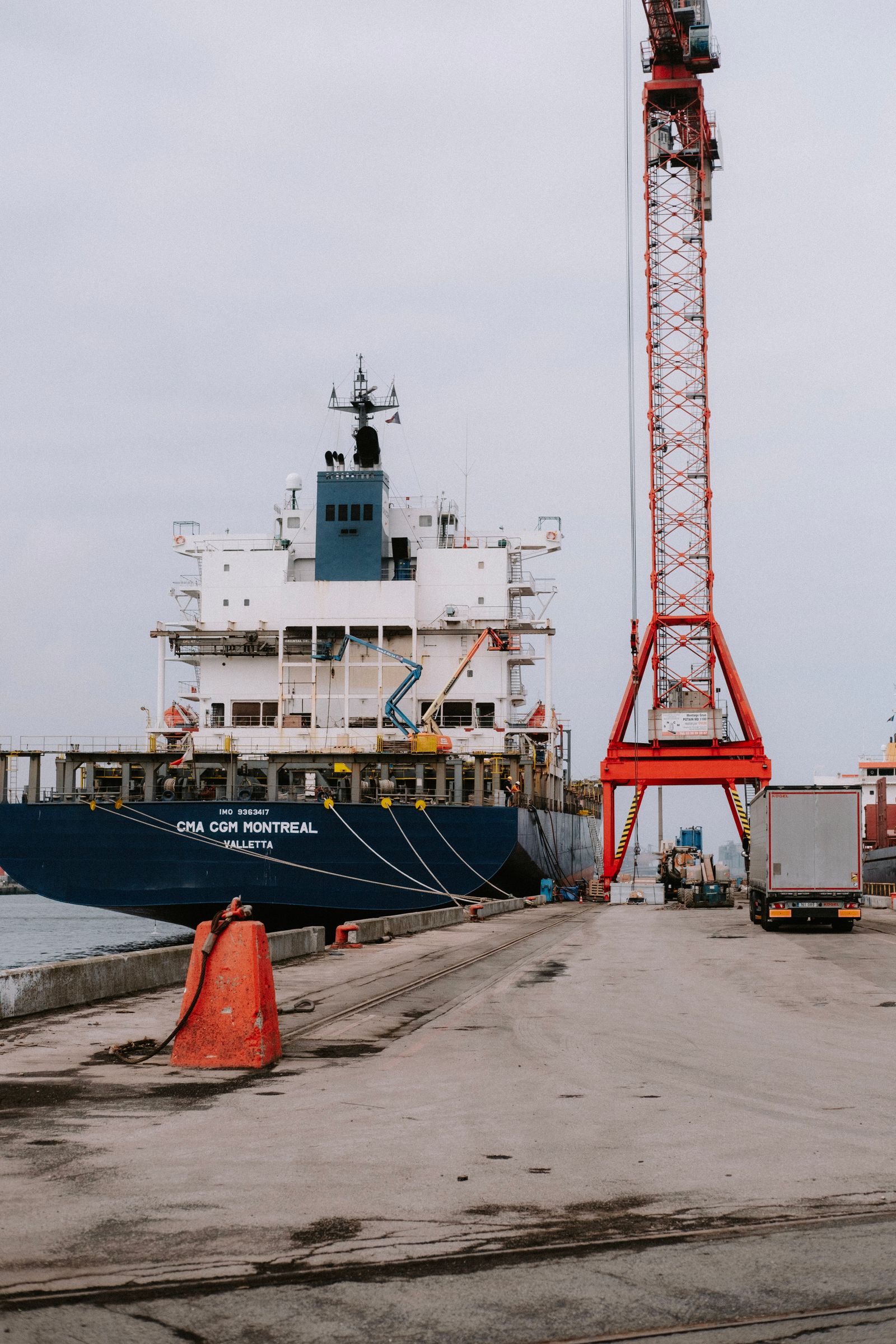 A container ship alongside cranes at an industrial port